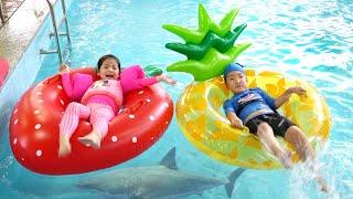 Seoeun is playing with a strawberry tube in the indoor pool