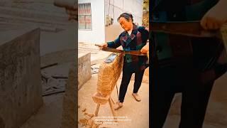 Carving a wooden chair-uses a large chisel-like tool to shape the wood