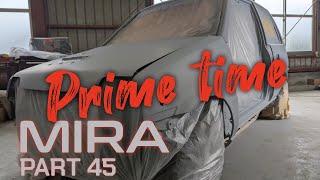 Priming the exterior of the Daihatsu Mira trxx after body repair work