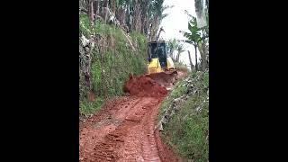 Komatsu D51EX Bulldozer Scrapes Soil for Construction of Downhill Road in Banana Plantation