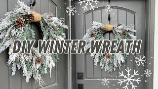 DIY cascading winter wreath with flocked evergreens and pinecones