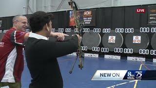 News 8's Jake Reyes attempts to shoot a bullseye