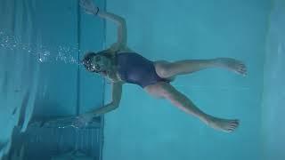 girl underwater try to sitting in mid water in 3m deep pool