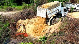 Wonderful First dump truck unloading stone into the build new road and bulldozer pushing fill up
