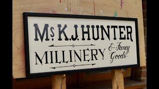 Traditional signwriting- hand painting a vintage style millinery business sign