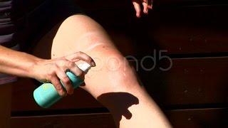 Woman Applies Sunscreen To Legs. Stock Footage