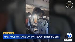 Passengers restrain unruly man kicking seat, smashing tray in violent outburst during flight | VIDEO