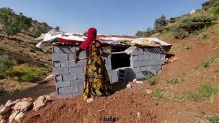 A single mother in the mountains:a baby in her arms and an unfinished hut