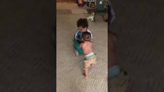 Infant Pushes His Older Brother In A Wagon