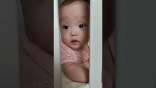 Sweet baby boy peeking through his crib