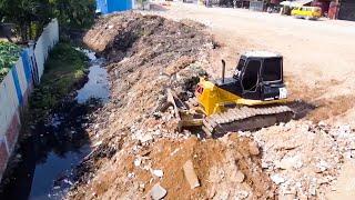 Komatsu Bulldozer Clearing Trash Off The Land Filling Into Mud In Village