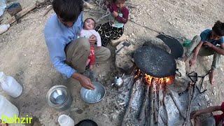 Preparing traditional bread for children's breakfast by nomadic father