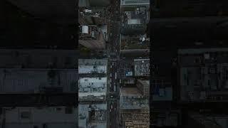 Vertical video reveals a Manhattan's bustling street with traffic and towering skyscrapers' rooftops