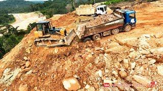 Top Dump Trucks dumping drop huge rocks on mountain & Bulldozer clearing stone in build road project