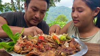 Naga couple eating best chicken parts with king chilly, eating in fresh and open surroundings.