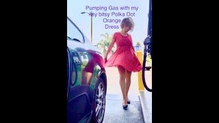 Windy day pumping gas with orange polka dot dress!