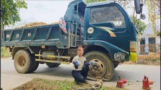 Mechanic girl rescues truck with broken tire in the middle of the road