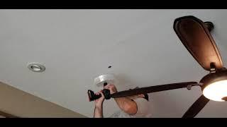 Cutting a 5" hole in ceiling sheetrock for can light with dust shield.