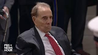 Bob Dole salutes President George H.W. Bush as he lies in state at the U.S. Capitol