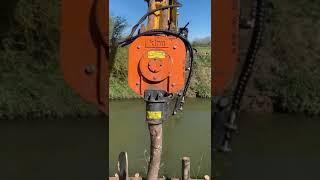 Klou KPD1 vibrating post driver attachment on long-reach excavator for bank stabilisation work.