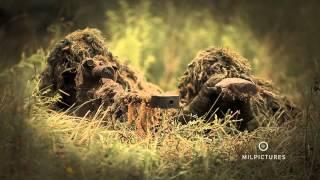 Sniper with ghillie suit shooting a heavy anti materiel sniper rifle