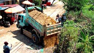 Perfectly action people pouring soil to build houses using dozer and truck7KIP spreading soil