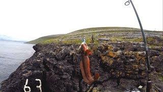 Rock fishing on cliffs in storm in Ireland.