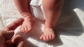 Bad daddy tickles feet of a newborn baby (7 days old)