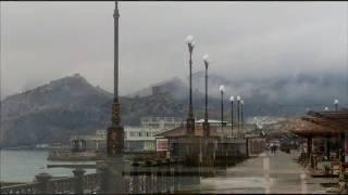 Крым в декабре. Набережная Судака пасмурным днём, тучи на горах.