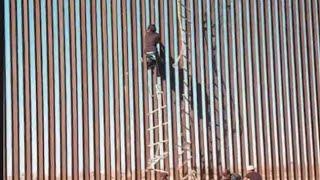 Climbing Mexico and United States Fence Patrol Officers At Work