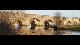 Bridging the Centuries. Motorcyclist on a Royal Enfield motorbike. By motorcycle in Northamptonshire