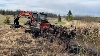 IHI 35GX excavator cleaning up dugout