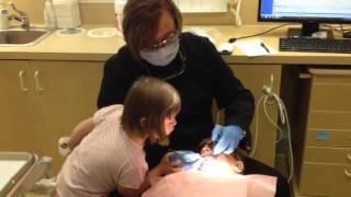 Pediatric dental examination with help from twin sister