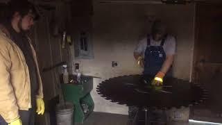 Hammering a circular sawmill blade.