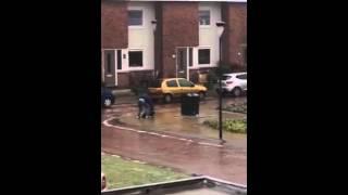 Guy cant put away his garbage because of the ice layered streets.