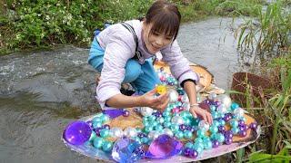 The girl opens a huge clam shell, revealing a dazzling and precious pearl cluster