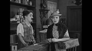 Charlie Chaplin, store clerk, helps forgetful customer (Edna Purviance)