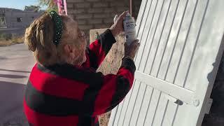 Pintando la puerta blanca de la casa de doña Beba