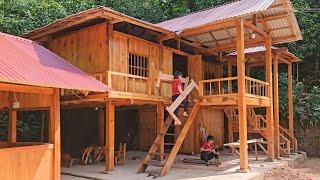 The girl builds the inside of the log house, using assembled wooden bars to make a bed frame