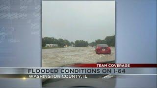 Cars drive along flooded I-64 in Washington County, Illinois