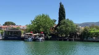 Dalyan boat tour passing the restaurants and boats in Dalyan River.