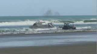 Boat launch in  big shorebreak waves New Zealand 90 mile beach