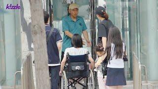 Citizens react to seeing an elderly man ignoring a woman in a wheelchair