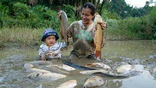 Single mother and baby go to the stream to find abandoned ponds to catch fish