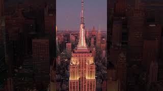 Aerial views highlight the Empire State Building rooftop in Midtown Manhattan at dusk. Sky shifts to