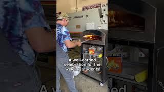 Students celebrate the end of the year with a pizza party using an oven made by the welding program.