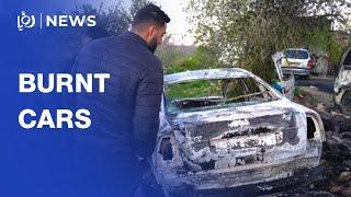 Palestinians check cars burnt by settlers in West Bank village