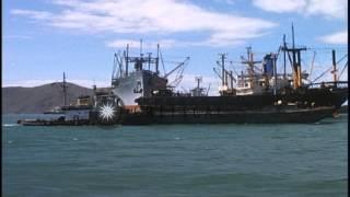 A barge-mounted crane lifts Land Craft Mechanized onto barge in Vietnam. HD Stock Footage
