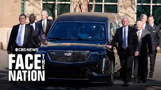 Secret Service agents walk alongside hearse carrying Jimmy Carter's casket