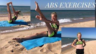 Gymnast Kira Khristenko shows ABS EXERCISES on a beach.